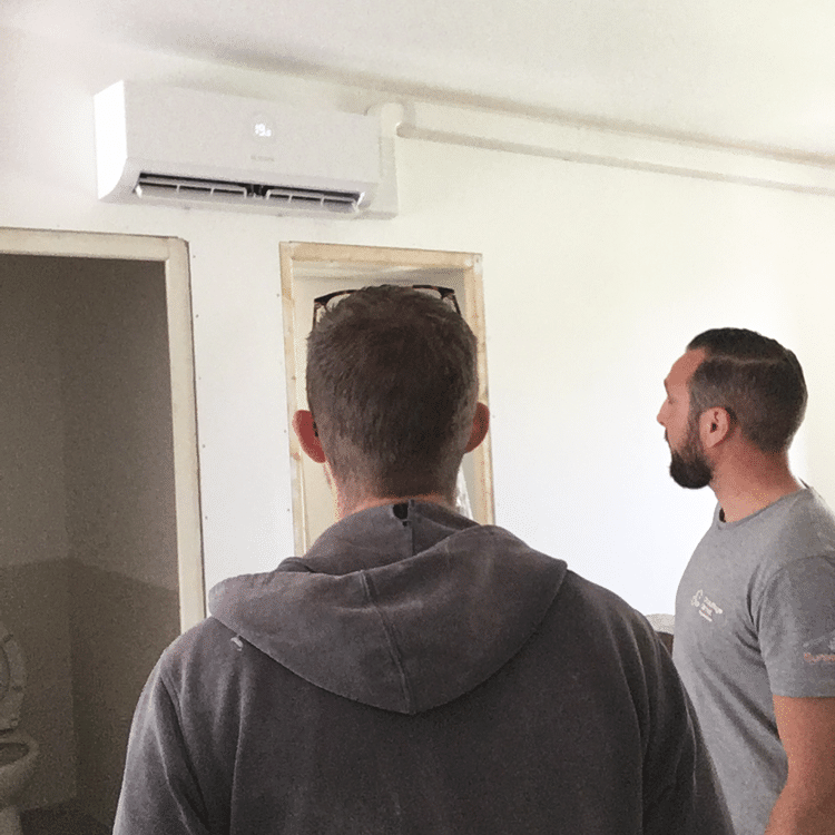 Installateurs de pompe à chaleur Groupe OPNR devant un appareil de chauffage.