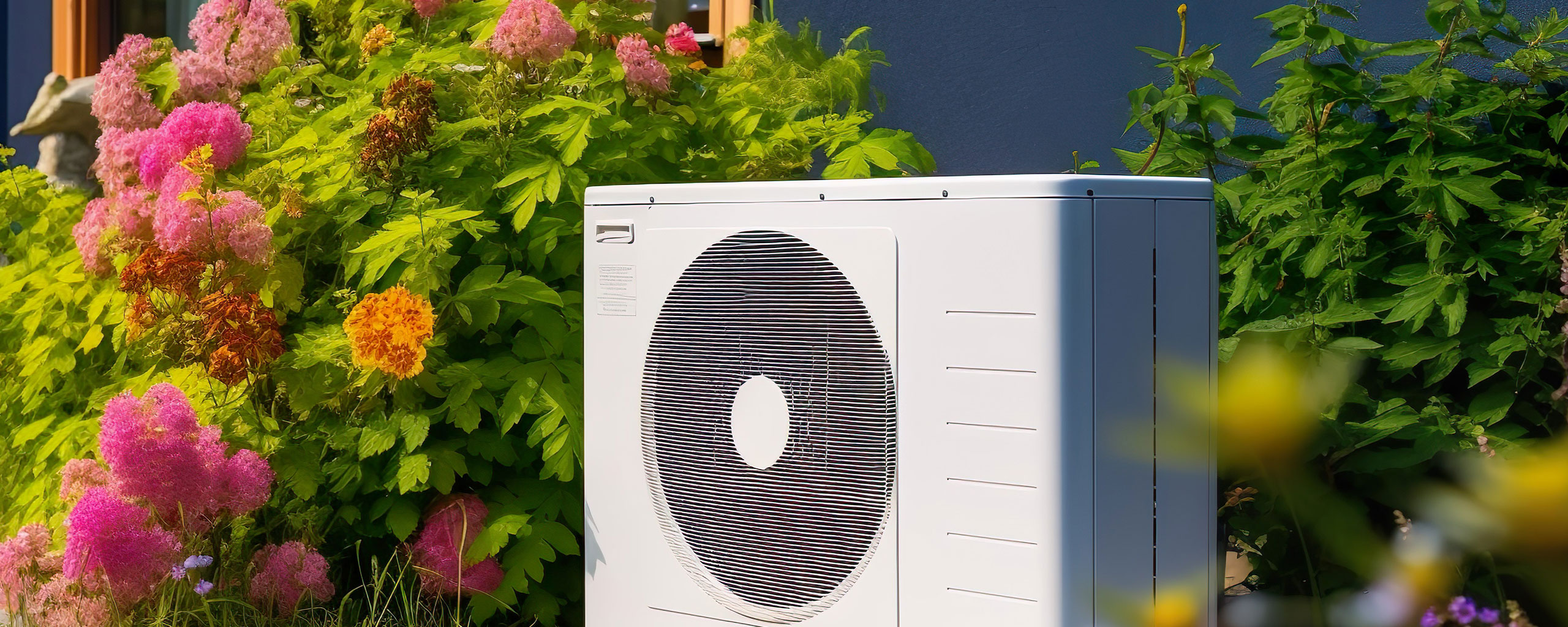Pompe à chaleur installée dans un jardin, solution de rénvation énergétique.