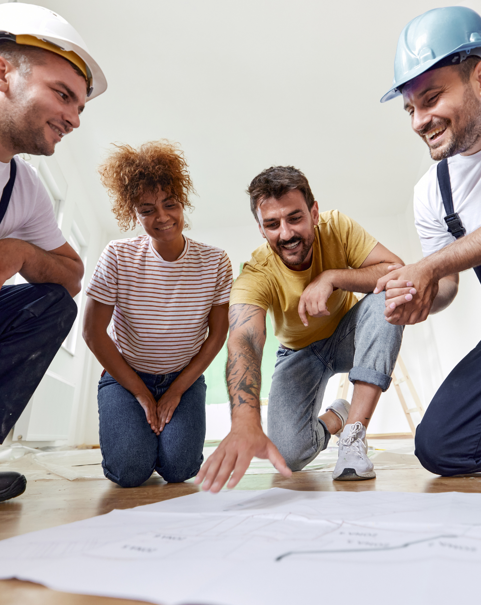 Des artisans expliquent les travaux qu’ils vont réaliser à un couple.