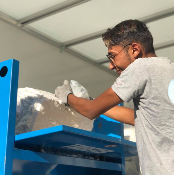 Artisan entrain de préparer la laine pour une isolation des combles.